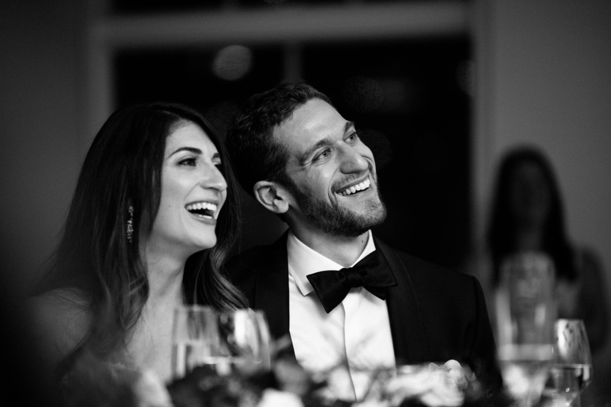 Black and White toasts happy candid laughing smiling husband and wife Hudson at Maritime Parc Jewish Wedding Jersey City
