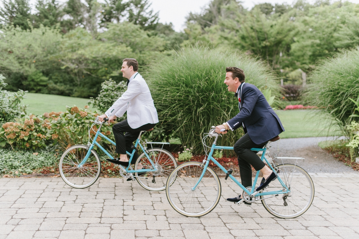 candid blue bicycles grooms beach town riding bikes The Chanler at Cliff Walk Newport Rhode Island New England Elegant Destination Wedding on the coast same sex couple lgbtq love is love gay couple love wins