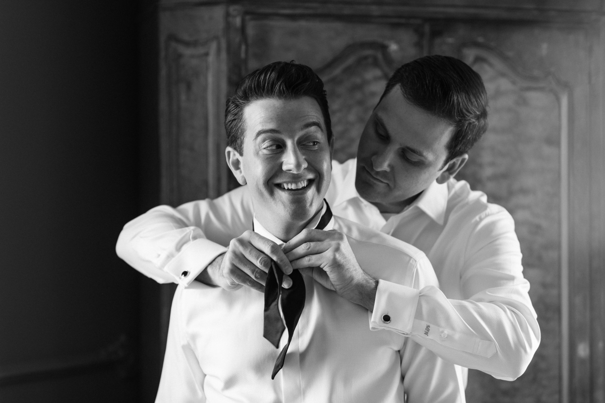 Candid getting ready groom prep happy black and white The Chanler at Cliff Walk Newport Rhode Island New England Elegant Destination Wedding on the coast same sex couple lgbtq love is love gay couple love wins