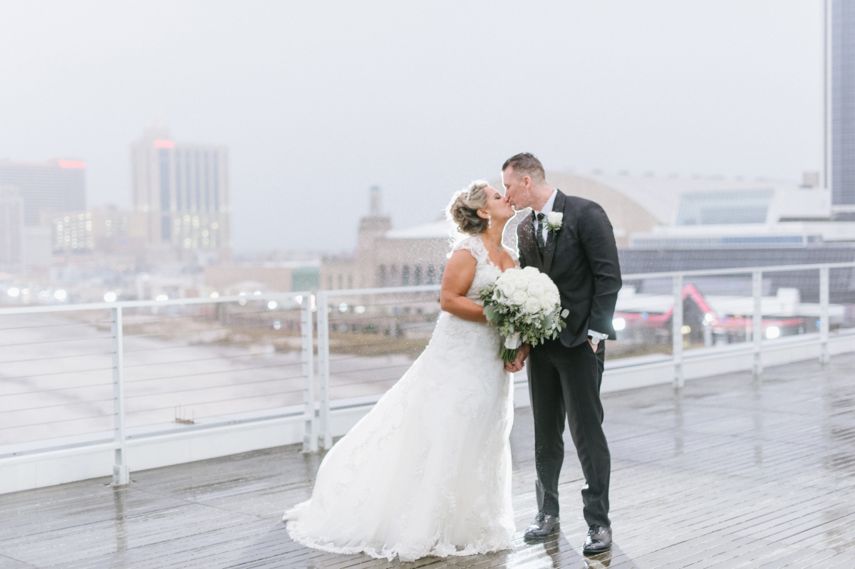 kissing by the water mist rain view beach One Atlantic Wedding Atlantic City New Jersey