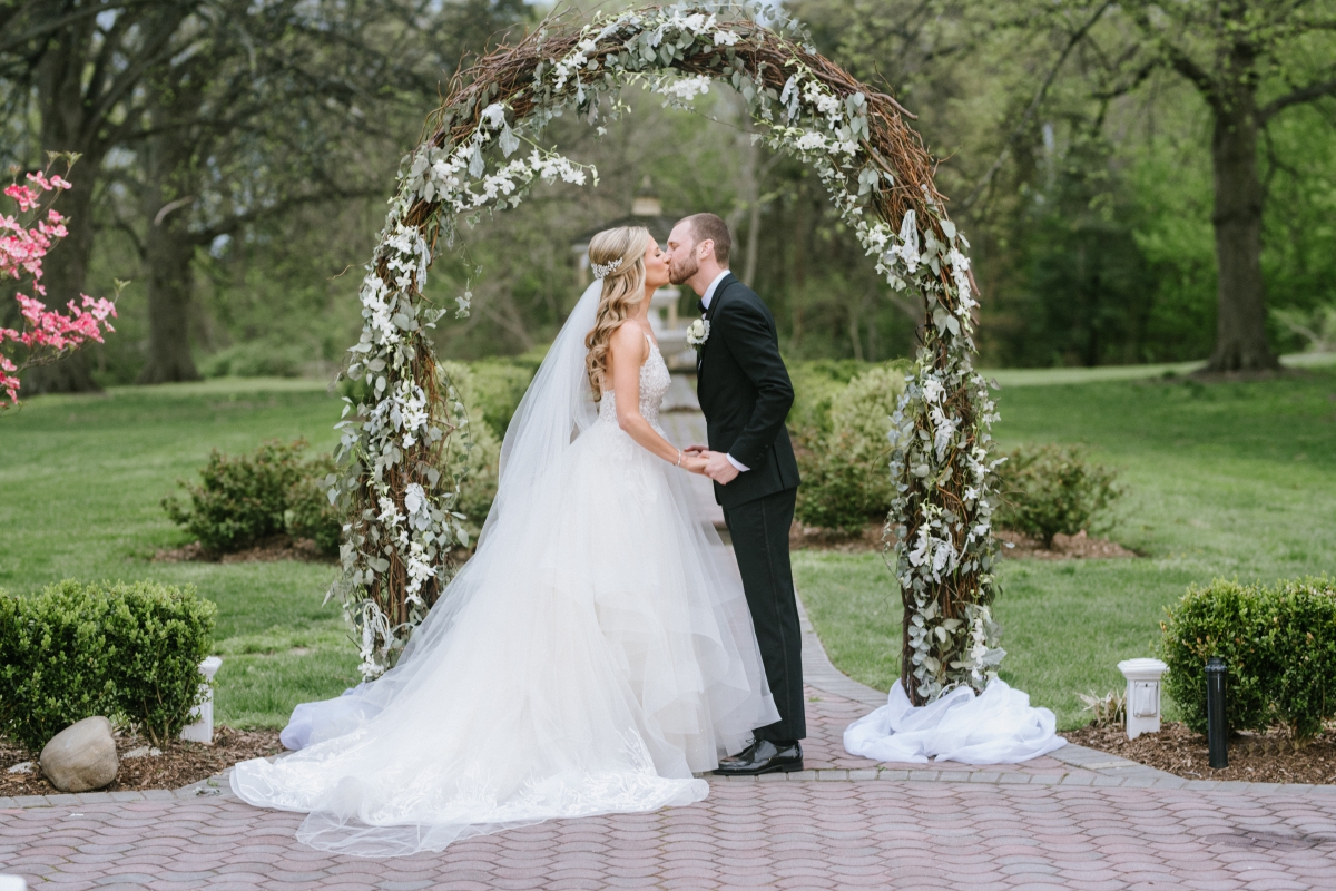 the mansion at oyster bay wedding woodbury nj ny new york wedding photography white floral archway ceremony kiss shot
