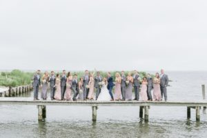 June Wedding Bonnet Island Estate Manahawkin LBI Long Beach Island Beach Jersey Shore Summer Ship Bottom soft pastel color palette floral design flowers bouquet happy couple laughter candid water bay island boardwalk dock bridal party bridesmaids groomsmen blush pink dresses navy and gray suits cheering happy