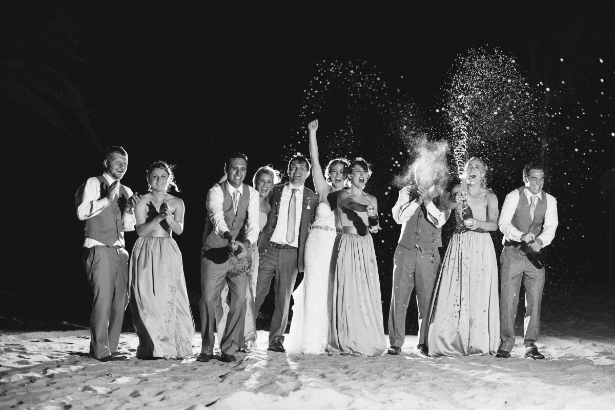 Black and white champagne pop bridal party excited happy night shot Windows on the Water Surfrider Beach Club Wedding