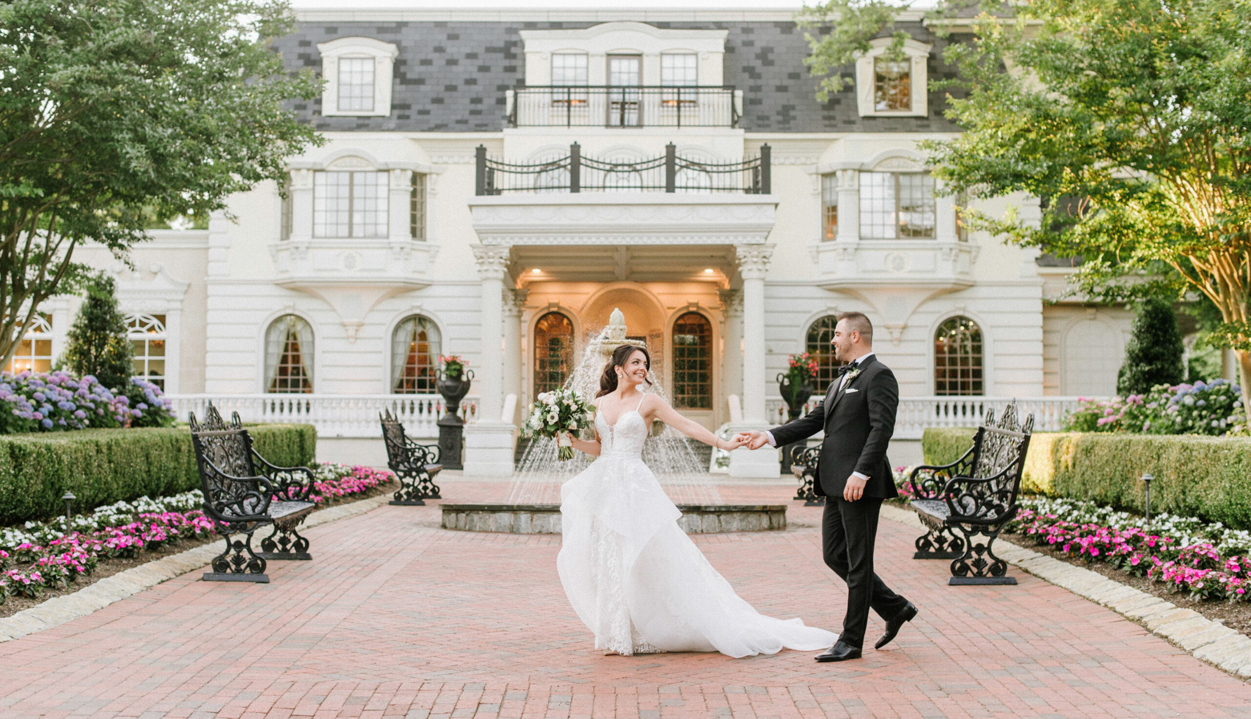 A joyful bride and groom outside The Ashford Estate in New Jersey. This elegant all-inclusive wedding venue features stunning grounds, classic architecture, and everything on site for a seamless wedding day