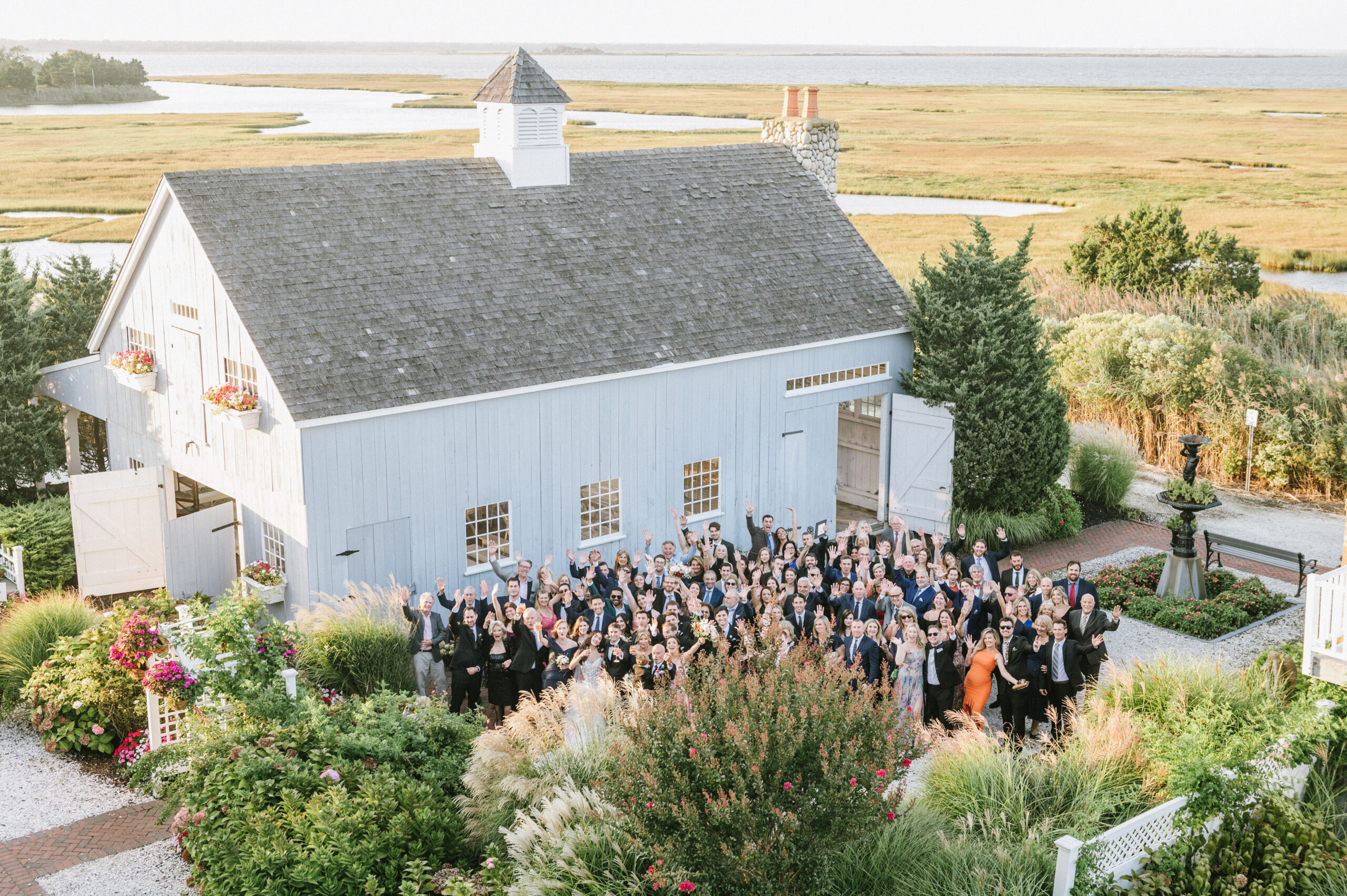 A view of the Bonnet Island Estate ceremony chapel surrounded by coastal marshland and wedding guests, showcasing the all-inclusive waterfront wedding venue in New Jersey.