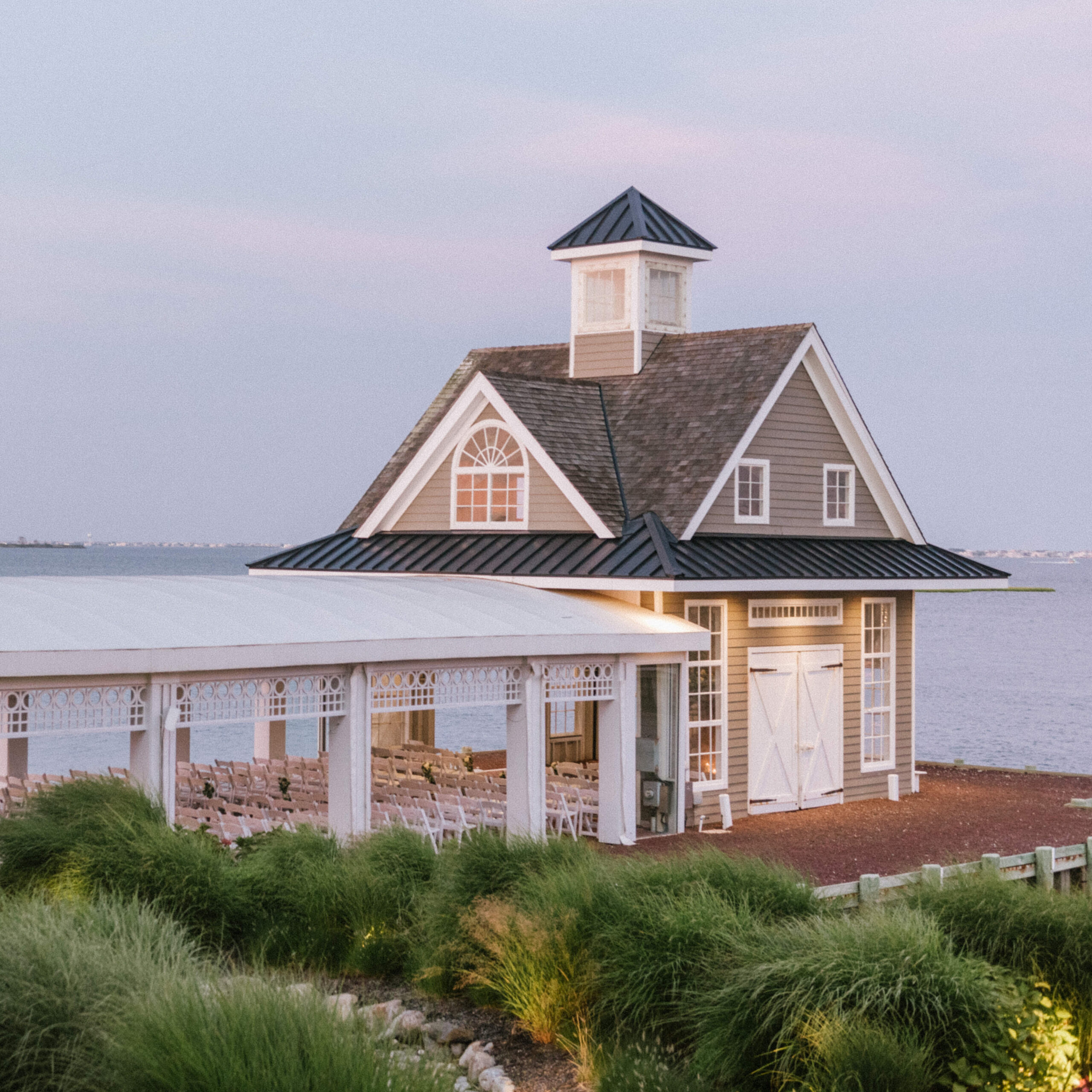 The waterfront ceremony at the boathouse chapel at Mallard Island Yacht Club overlooking the bay at sunset.