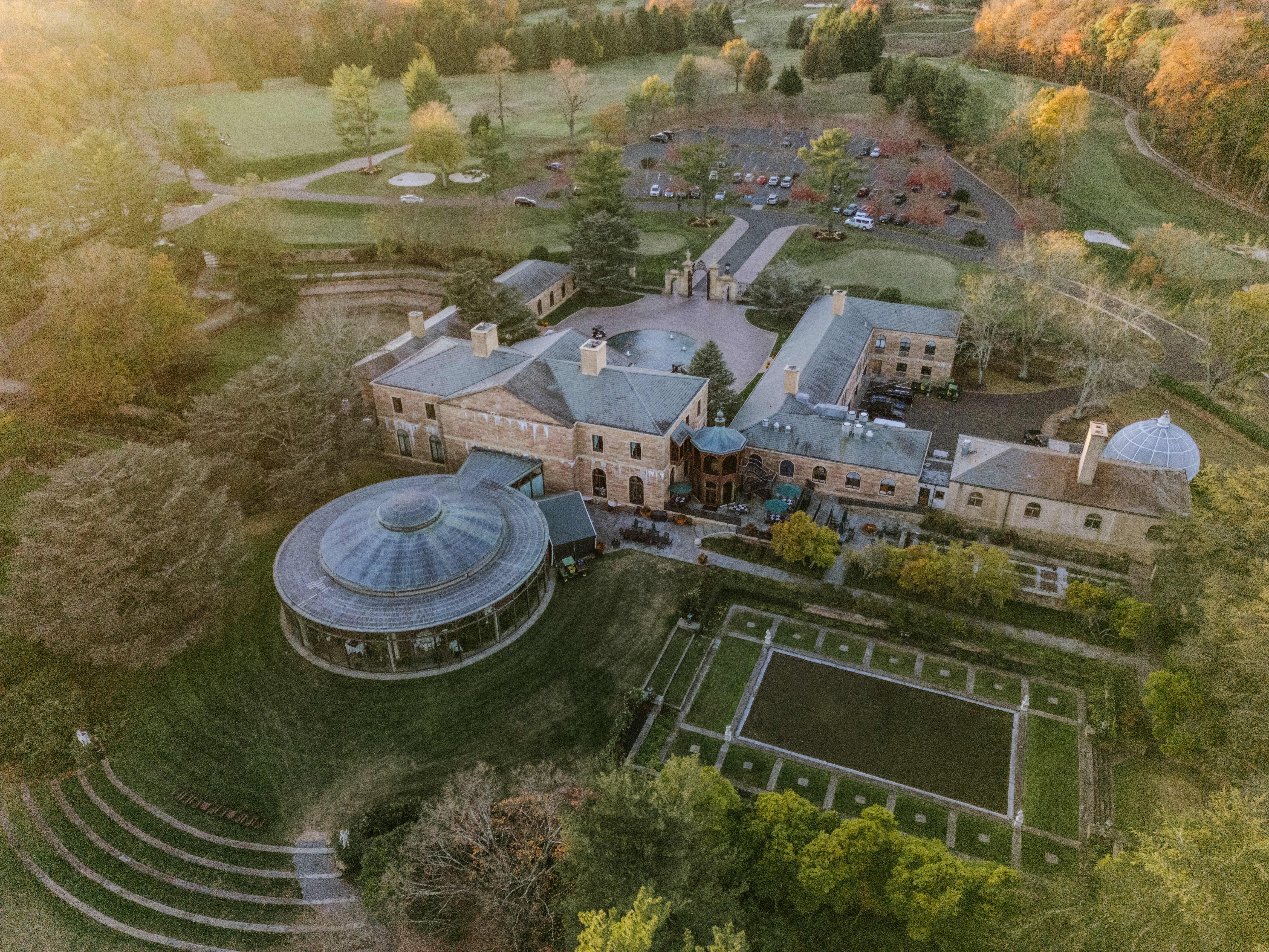 Aerial view of Jasna Polana wedding venue in Princeton NJ featuring the historic estate, gardens, reflecting pool, and glass ballroom surrounded by the golf course.